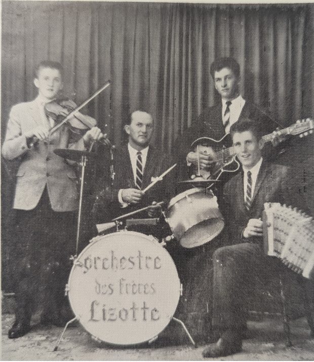 Photographie en noir et blanc de l’orchestre des Frères Lizotte. De gauche à droite, ne veston et cravate : Jean-Paul Lizotte, Jean-Léon Pelletier, Maurice Lizotte et Réjean Lizotte. Certains sont assis et d’autres sont debout devant un rideau.