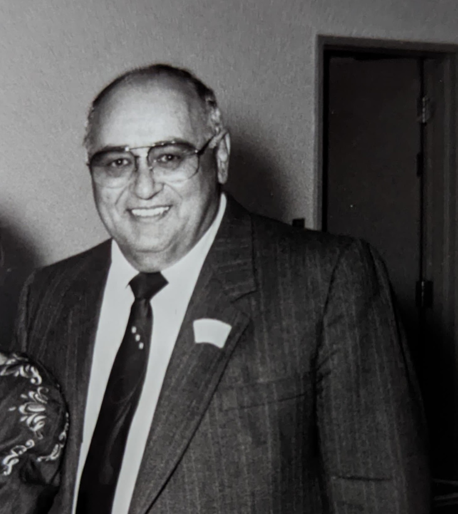 Photographie en noir et blanc montrant Armand Labrecque lors du lancement de l’édition de 1991 du Carrefour mondial de l’accordéon de Montmagny. Il est vêtu d’un complet et d’une cravate.