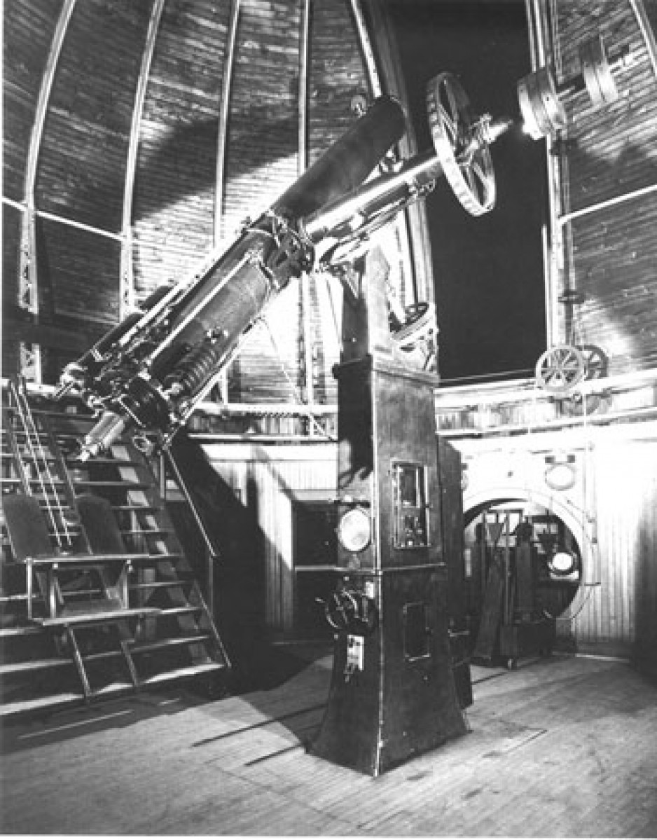 Image en noir et blanc d’une lunette astronomique de 15 pouces. Le télescope est fixé à un pilier de montage et se trouve à l’intérieur d’un bâtiment en forme de coupole. Une ouverture dans la coupole permet d’observer le ciel nocturne au moyen du télescope.