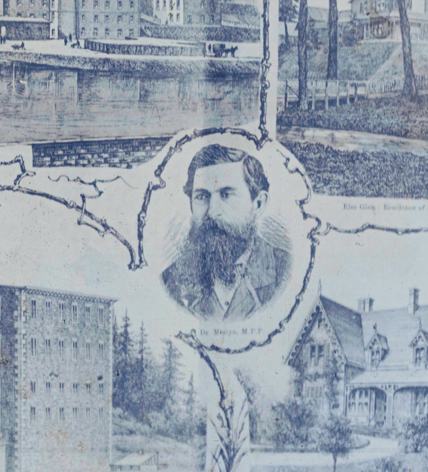 Dessin gravé en noir et blanc du docteur William Mostyn entouré d'un collage de bâtiments et de rues d'Almonte. Il porte une chemise blanche et un costume sombre. Il a une barbe et des cheveux bien coiffés.