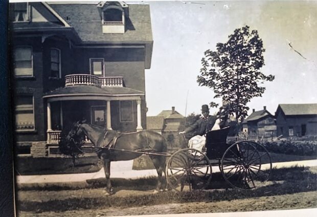 Photographie en noir et blanc du docteur Hanly dans sa voiture hippomobile. La photo a été prise sur la rue Church, à Almonte.