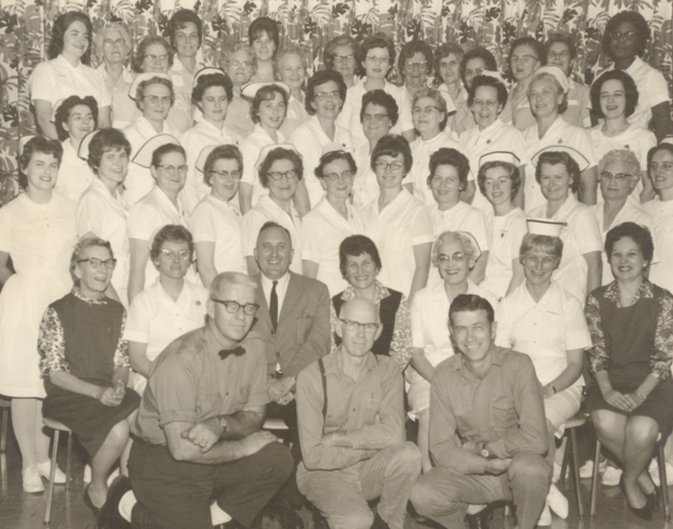 Photographie en noir et blanc d'infirmières à l'hôpital général d'Almonte. Trois rangées d'infirmières sont debout et une rangée d'infirmières est assise. Il y a trois hommes au premier rang.