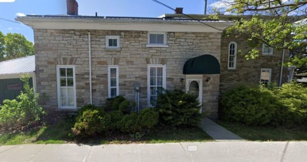 Photographie en couleur de la façade de la maison du docteur, une maison en pierre avec des fenêtres blanches, en mai 2023 à Almonte.