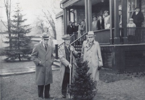 Photographie en noir et blanc d’une cérémonie de plantation d’arbre à l’hôpital Rosamond Memorial avec docteur Dunn, docteur Metcalfe et docteur Kelly. 