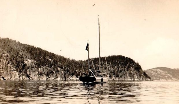 Photographie noir et blanc d’un petit voilier à deux mats, voiles déployées, amarré dans quelques centimètres d’eau. Le titre « L’Empress Tadoussac II. Robert Harrington Smith, vers 1950 »