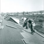 Les constructeurs posent des bardeaux sur les maisons le long de Lakeside Drive, dans les premiers temps de la construction