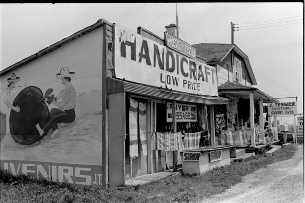 Photo en noir et blanc d'un kiosque d'artisanat attenant à une maison sur le bord de la route 138.