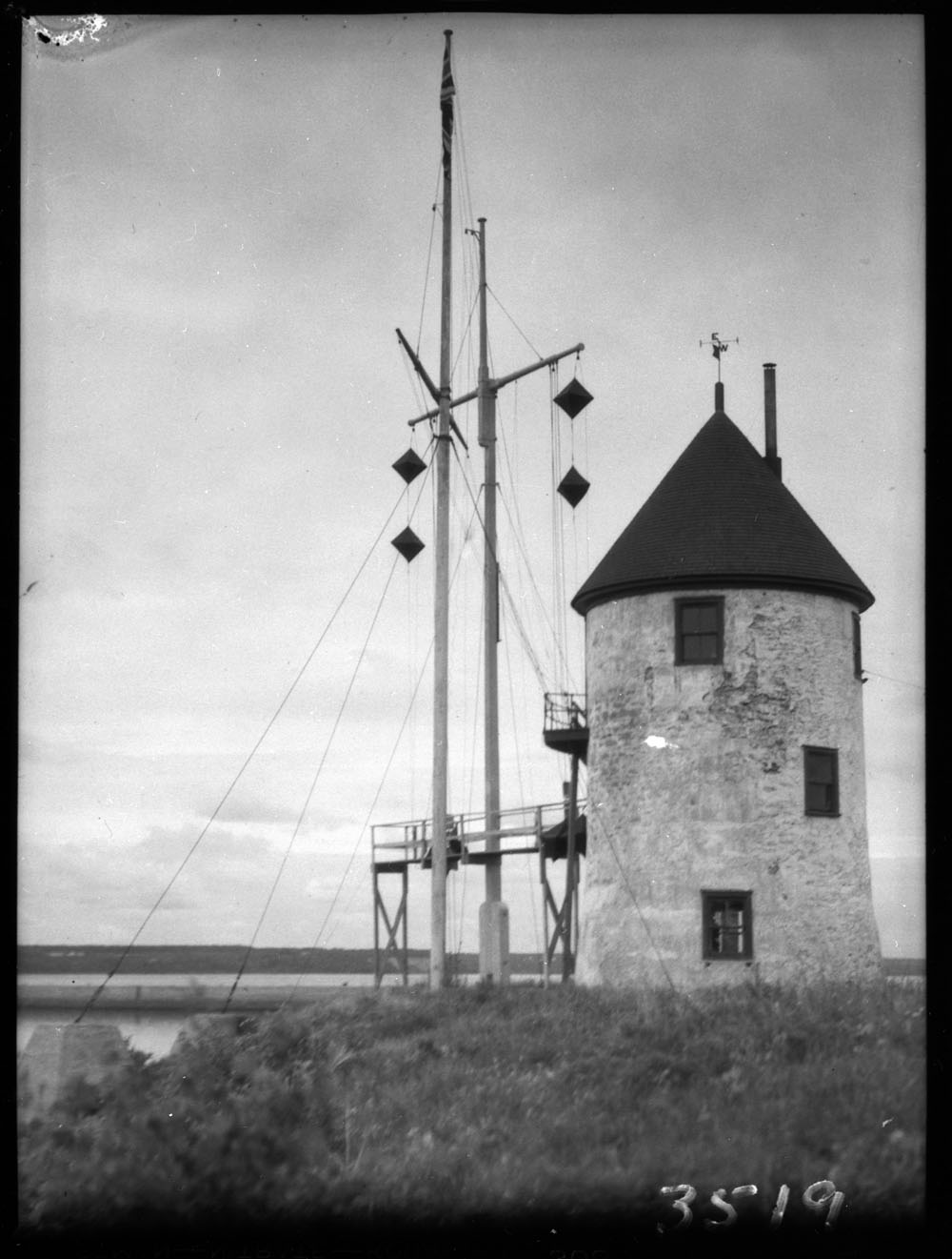 Photo en noir et blanc du moulin à vent sans ailes doté de deux mâts. 