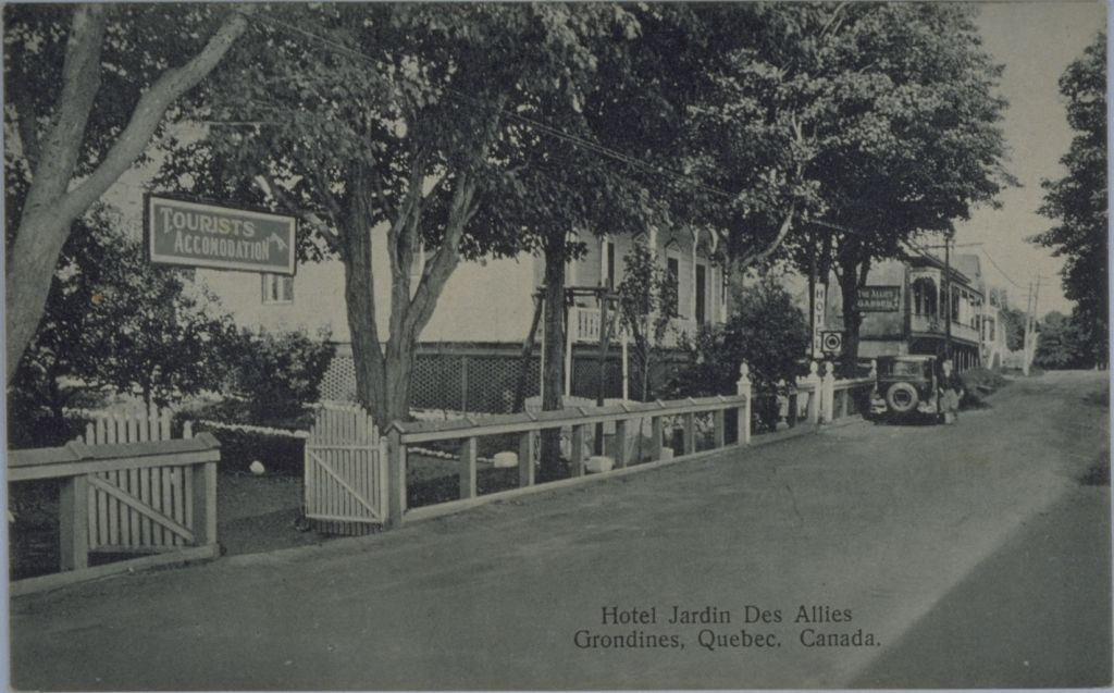 Photo en noir et blanc d'une route et d'une devanture d'hôtel.