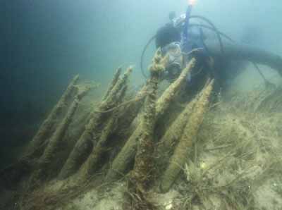 Photographie sous-marine d'un plongeur observant la structure en bois restante des barrages de pêche de Mnjikaning.