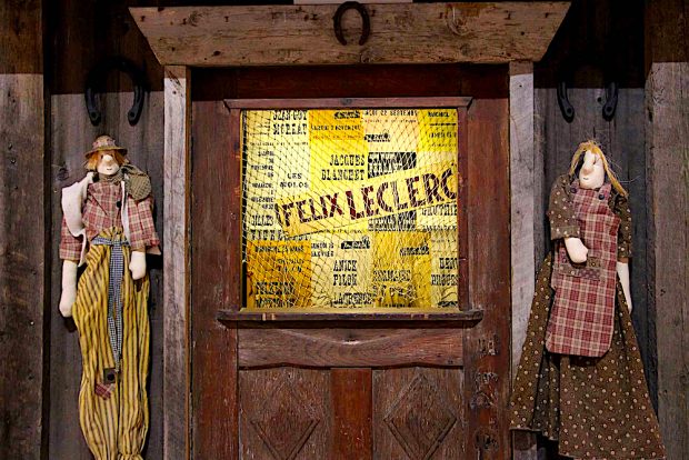 Photo couleur de la porte-guichet de la Butte et de deux marionnettes lors de l’exposition de 2021.