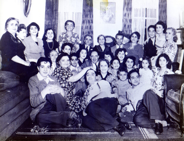 Groupe de 29 personnes, dont 8 hommes, 19 femmes, un garçon et une fille. Le groupe est assis ensemble dans une salle de séjour et porte des vêtements semi-formels.