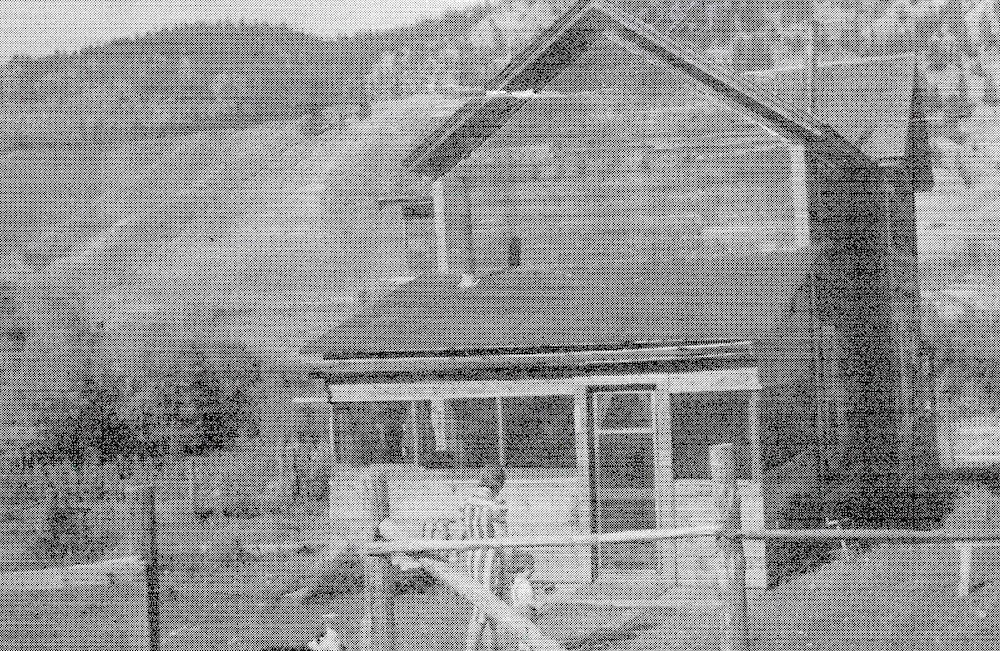 Femme et enfant marchant vers une maison devant une colline