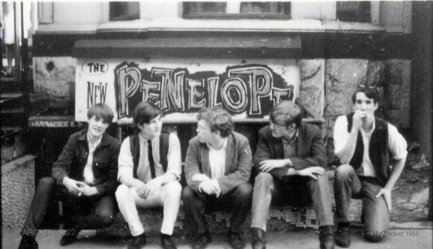 Photographie en noir et blanc de cinq jeunes membres du groupe Sidetrack assis en plein air devant un panneau indiquant The New Penelope.