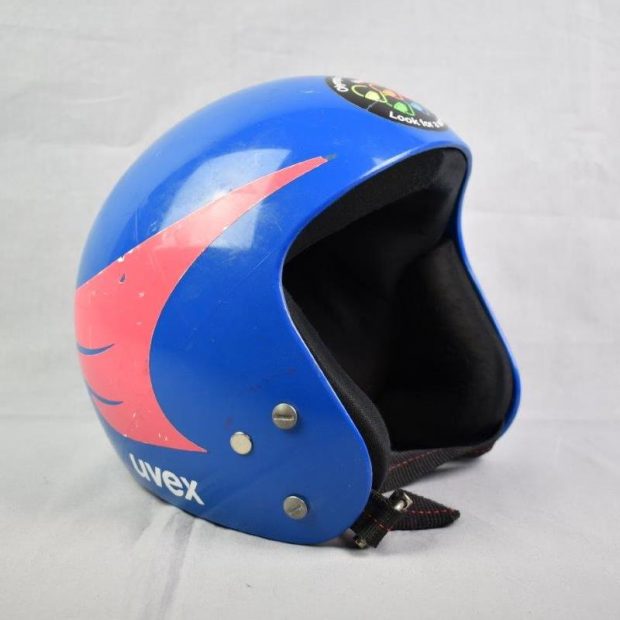 Casque de course bleu orné d’une aile rose du côté gauche.