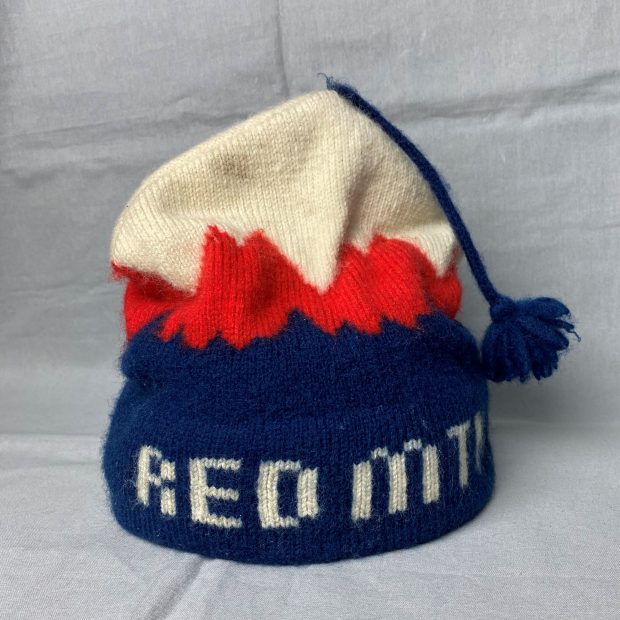 Tuque bleue, rouge et blanche avec un pompon à franges bleu