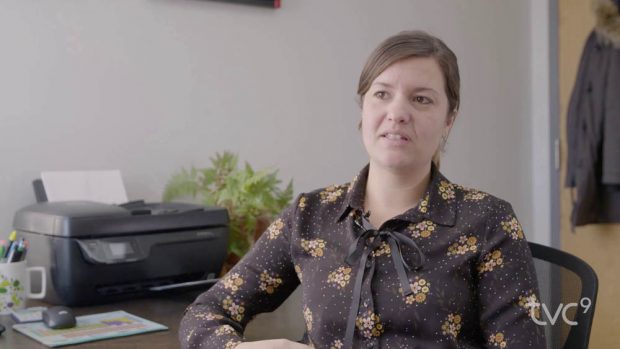 Prise de vue d'une femme assise dans un bureau, en pleine discussion.