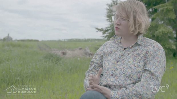 Prise de vue extérieure sur une personne assise avec un champ agricole en arrière-plan.