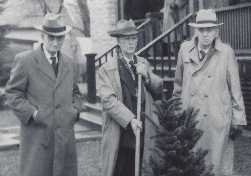 Photographie en noir et blanc d’une cérémonie de plantation d’arbre à l’hôpital Rosamond Memorial avec docteur Dunn, docteur Metcalfe et docteur Kelly.